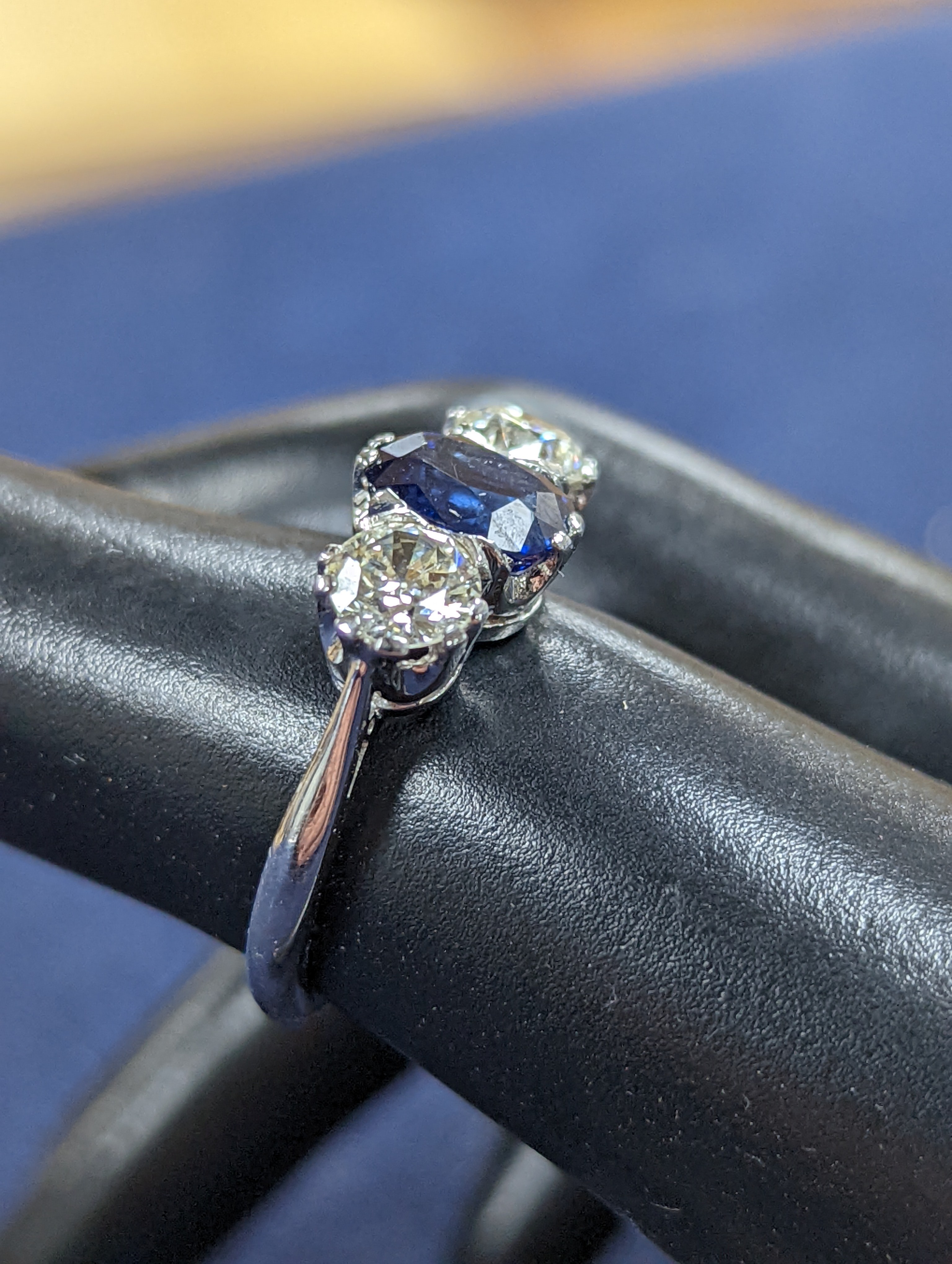 A modern 18ct white gold, single stone sapphire and two stone diamond set ring, size L, gross weight 4.2 grams